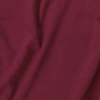 Burgundy fabric swatch with brushed texture, labeled “vismara eco nabuk,” draped to show matte finish and consistent color against a light gray backdrop.